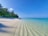 A serene beach with crystal clear water and a vibrant coral reef.
