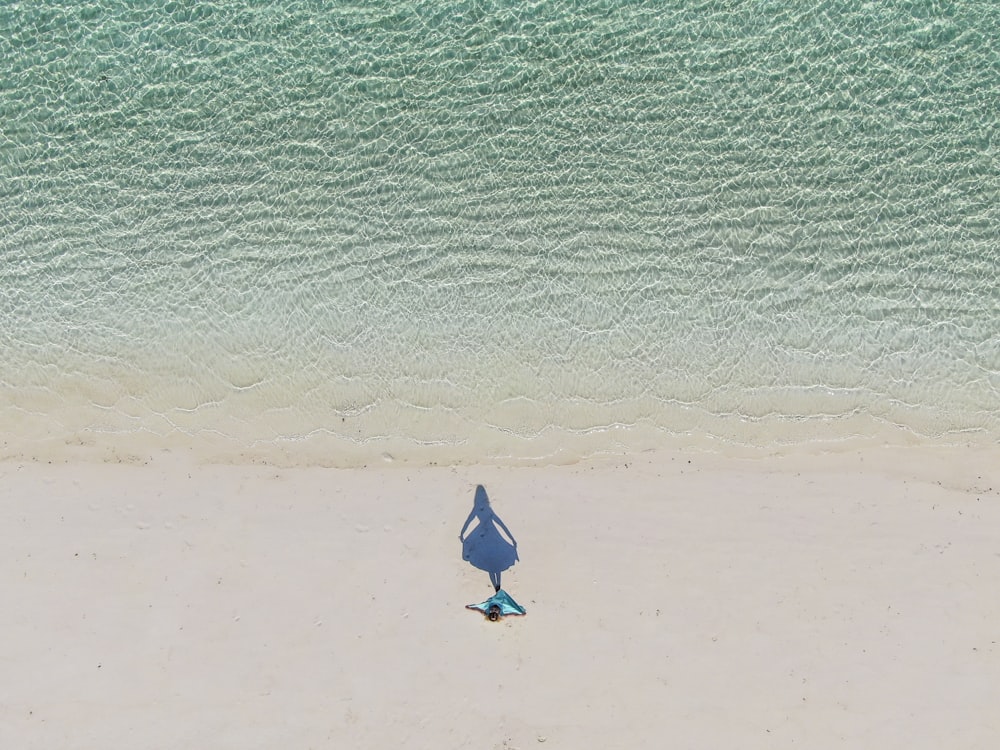 a person standing on a beach with a surfboard