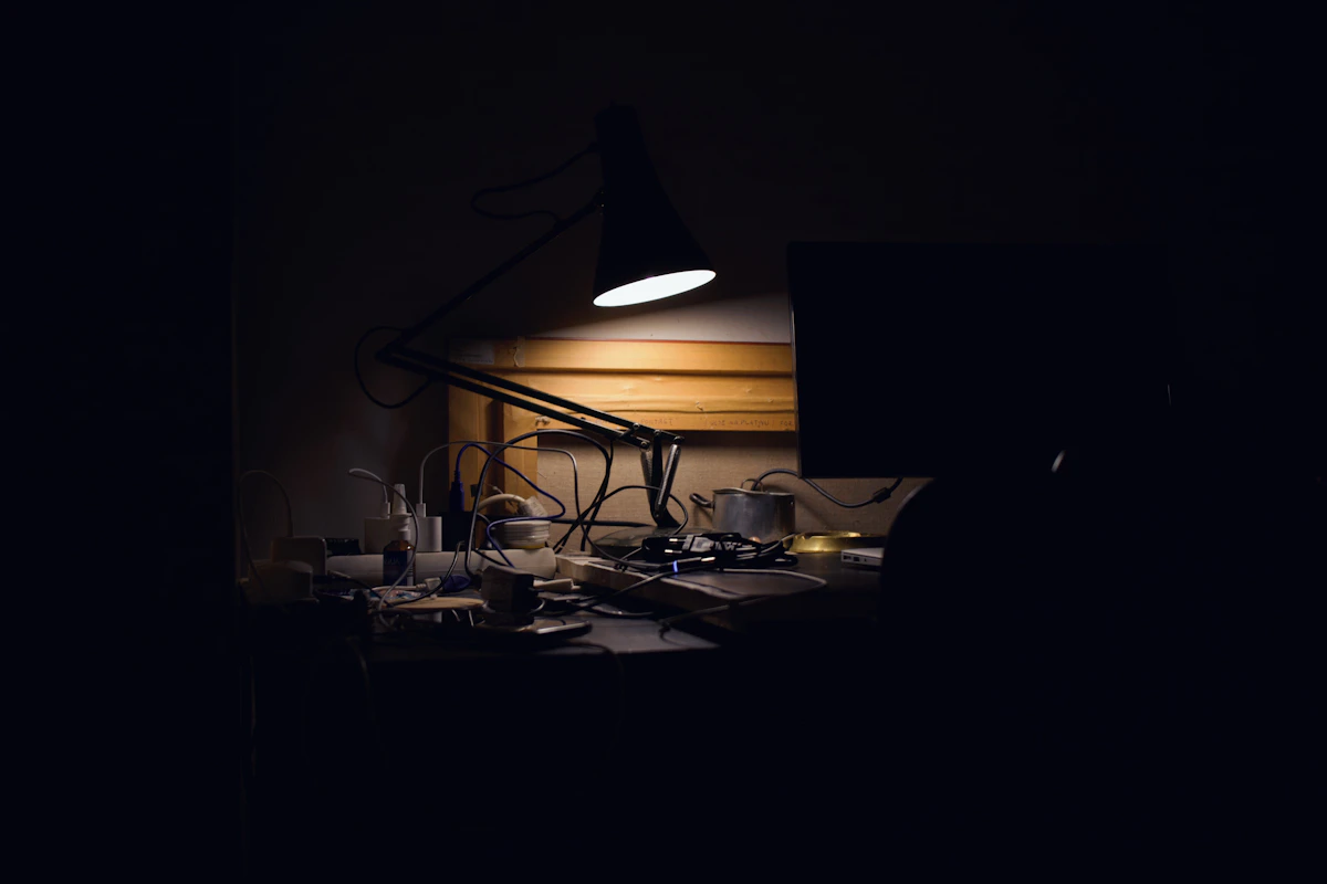 Warm desk lamp illuminating a quiet workspace
