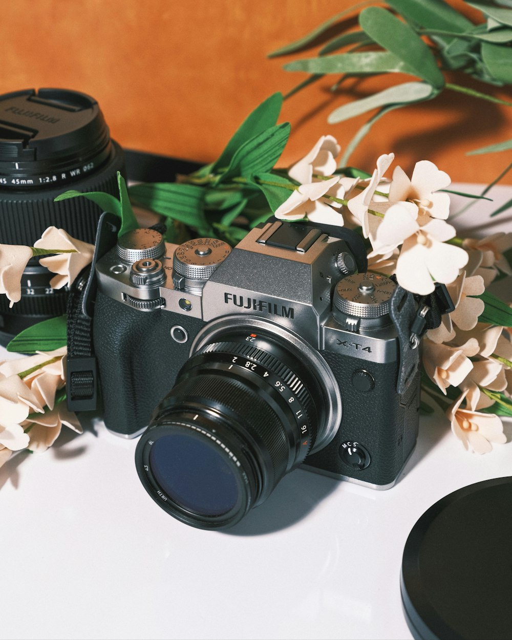 a camera and some flowers on a table