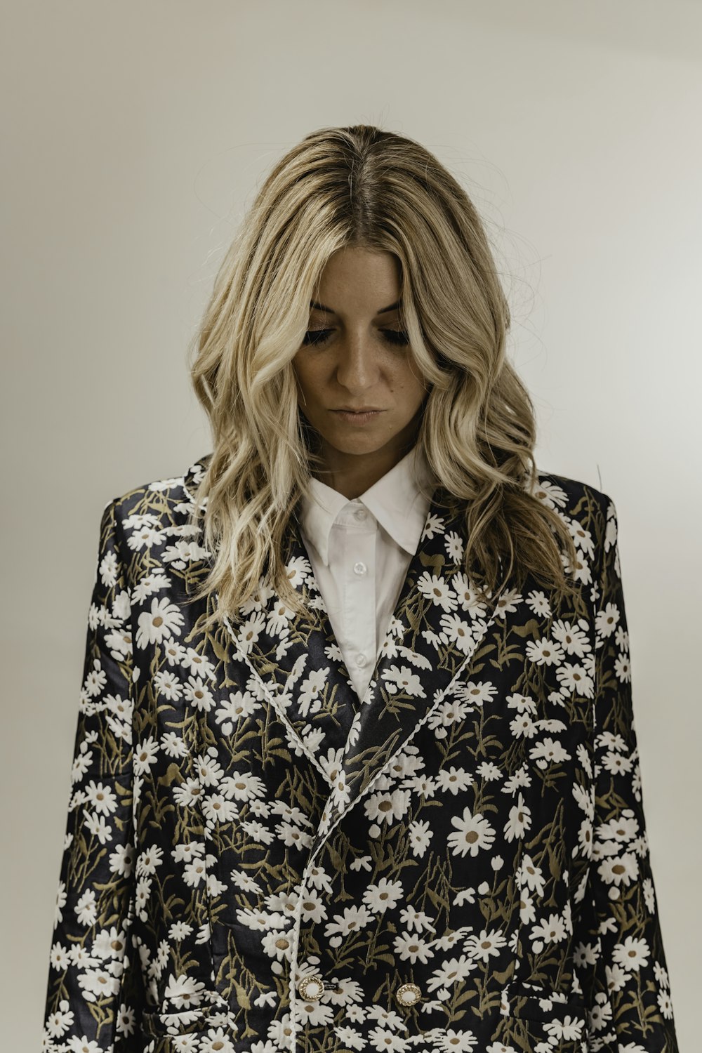 a woman in a black and white floral suit