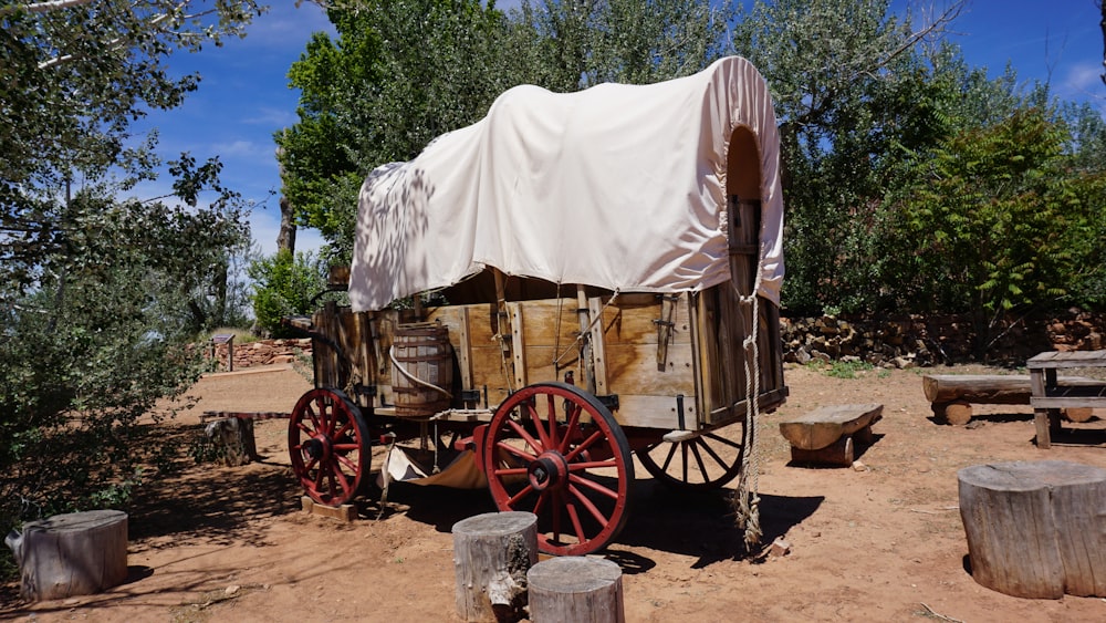 a covered wagon sitting in the middle of a dirt field