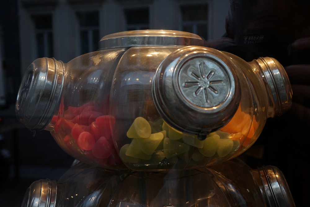 a glass jar filled with gummy bears on top of a table
