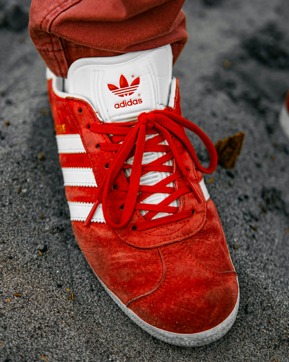a close up of a person's red adidas sneakers