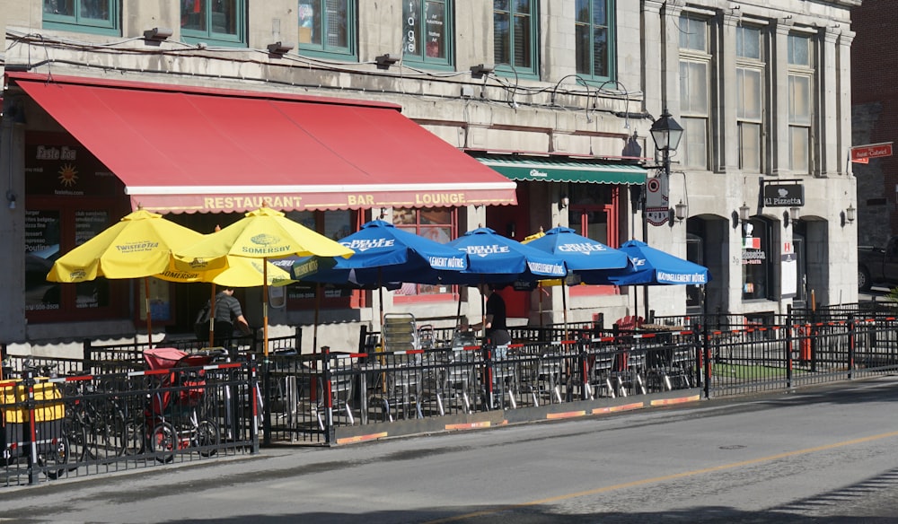 a row of yellow and blue umbrellas sitting on the side of a road