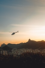 An elegant helicopter soaring above the vibrant cityscape of Raipur at dusk, highlighting premium air travel.