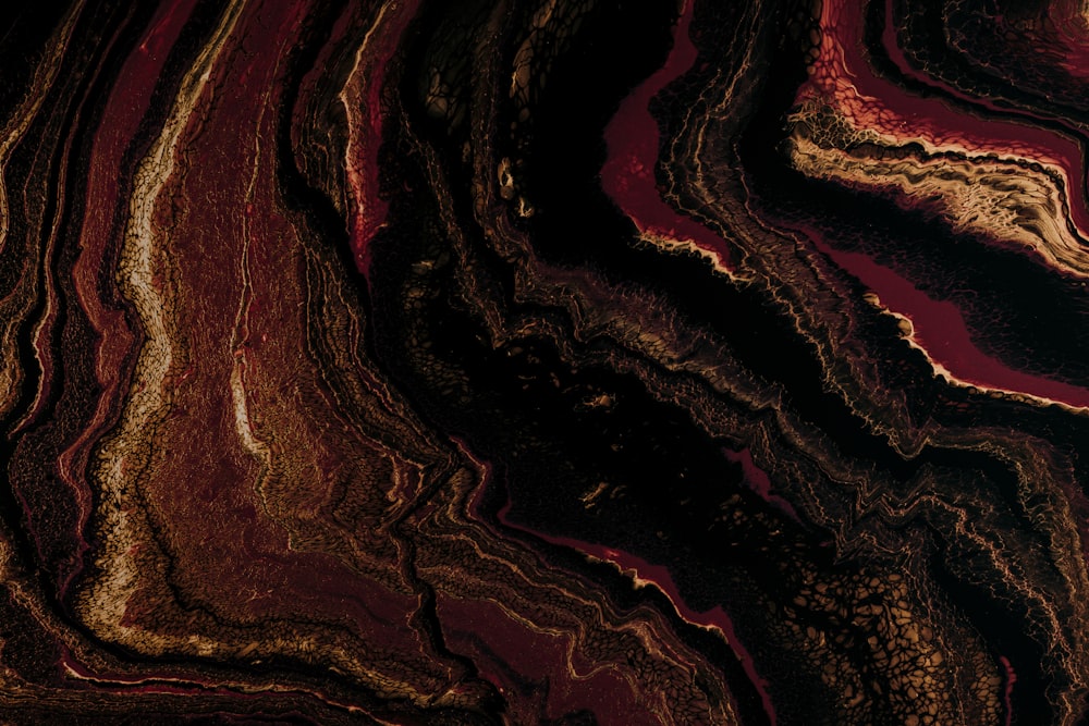 a close up of a red and gold marble