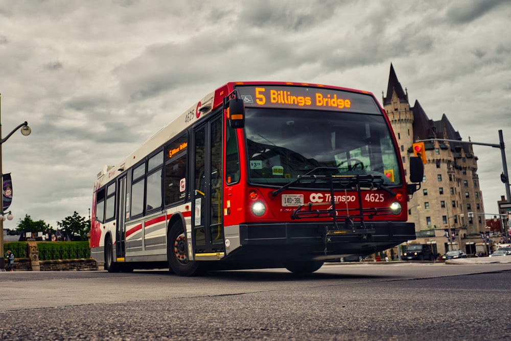 a red and white bus driving down a street