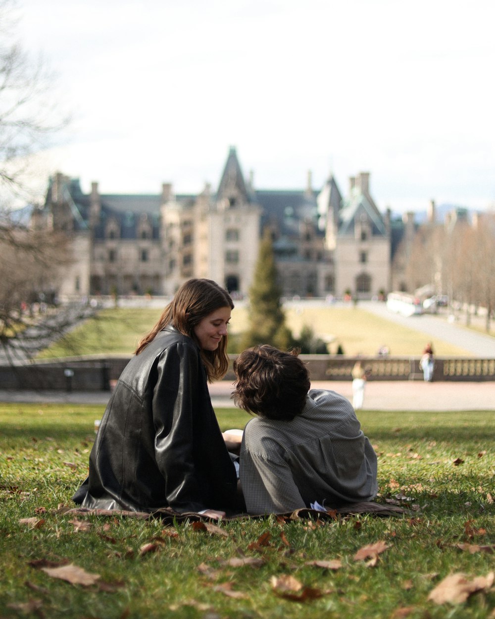 a couple of people that are sitting in the grass