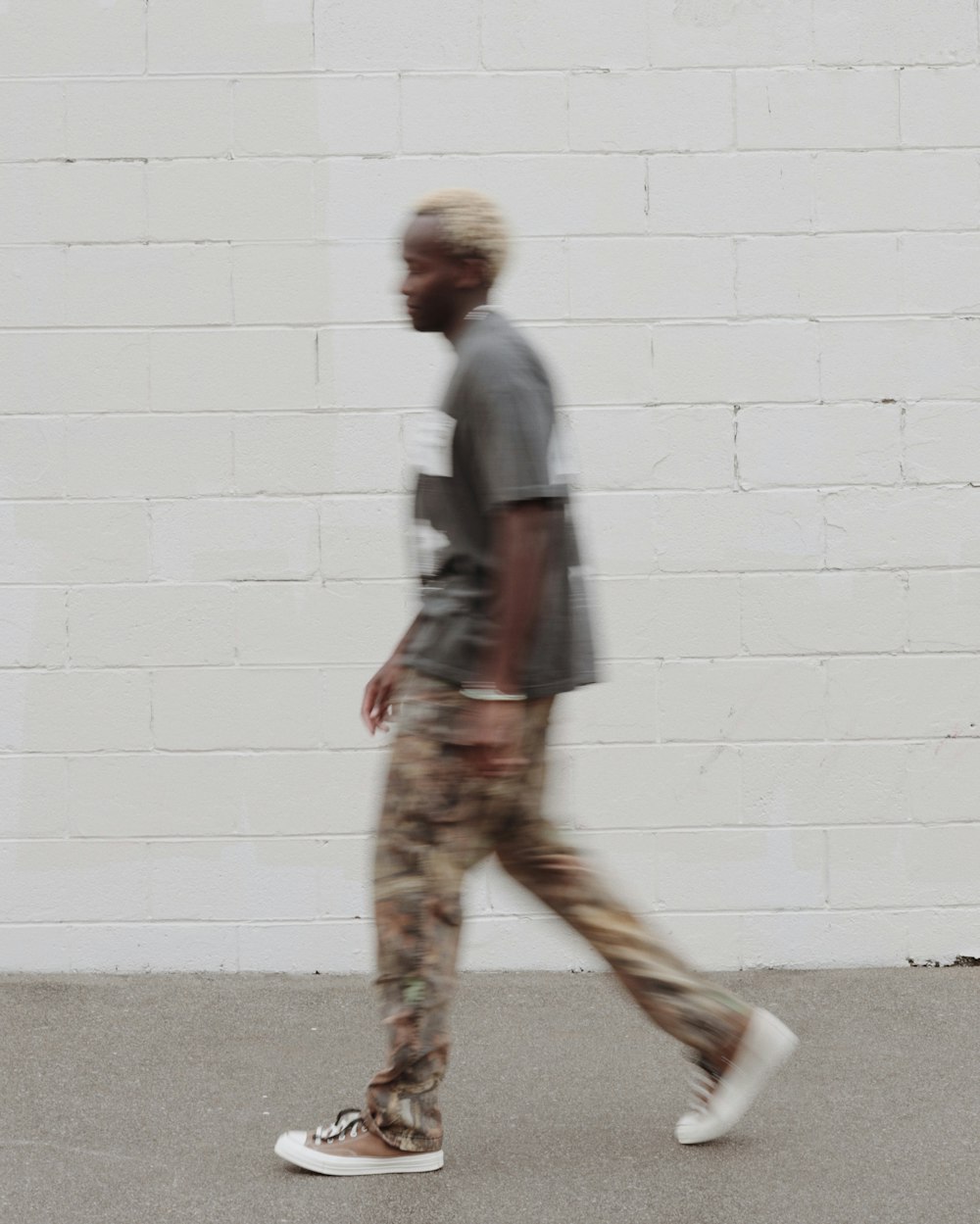 a person standing next to a brick wall