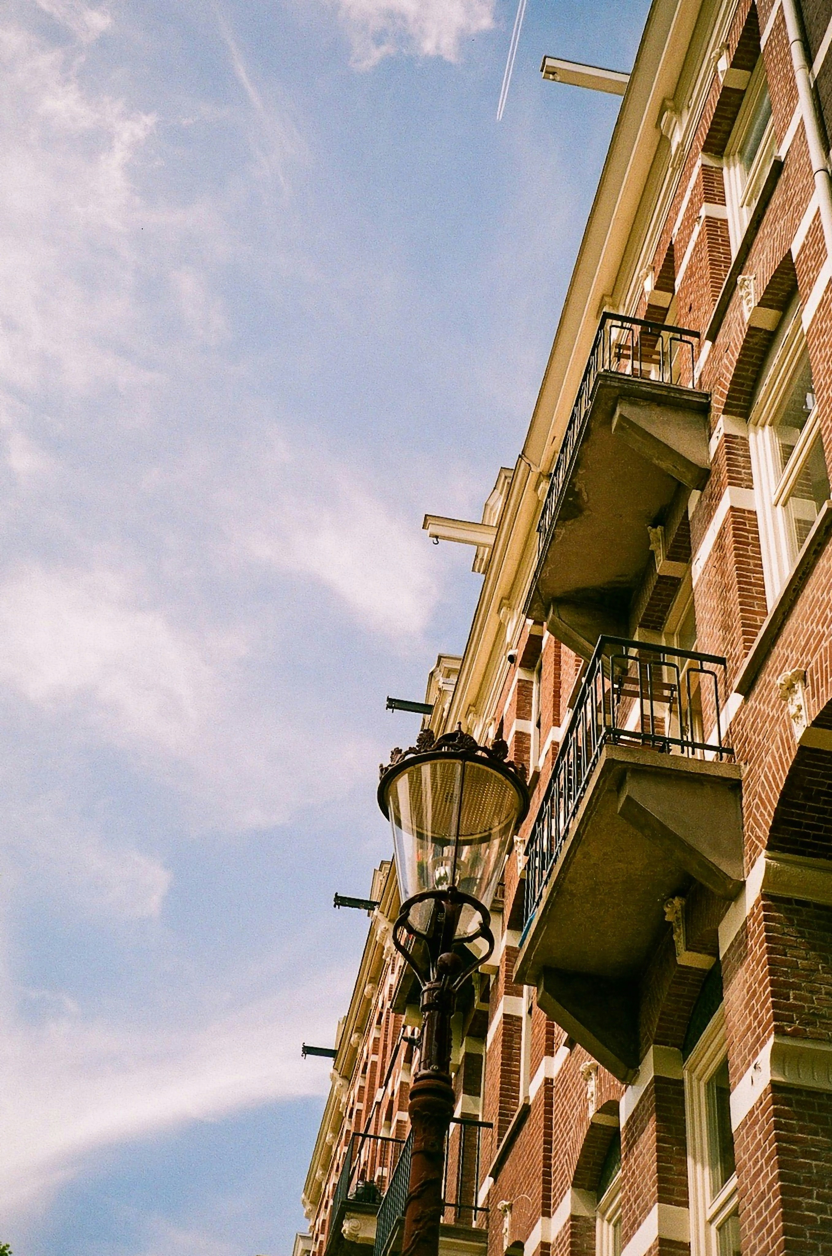 a street light sitting next to a tall brick building