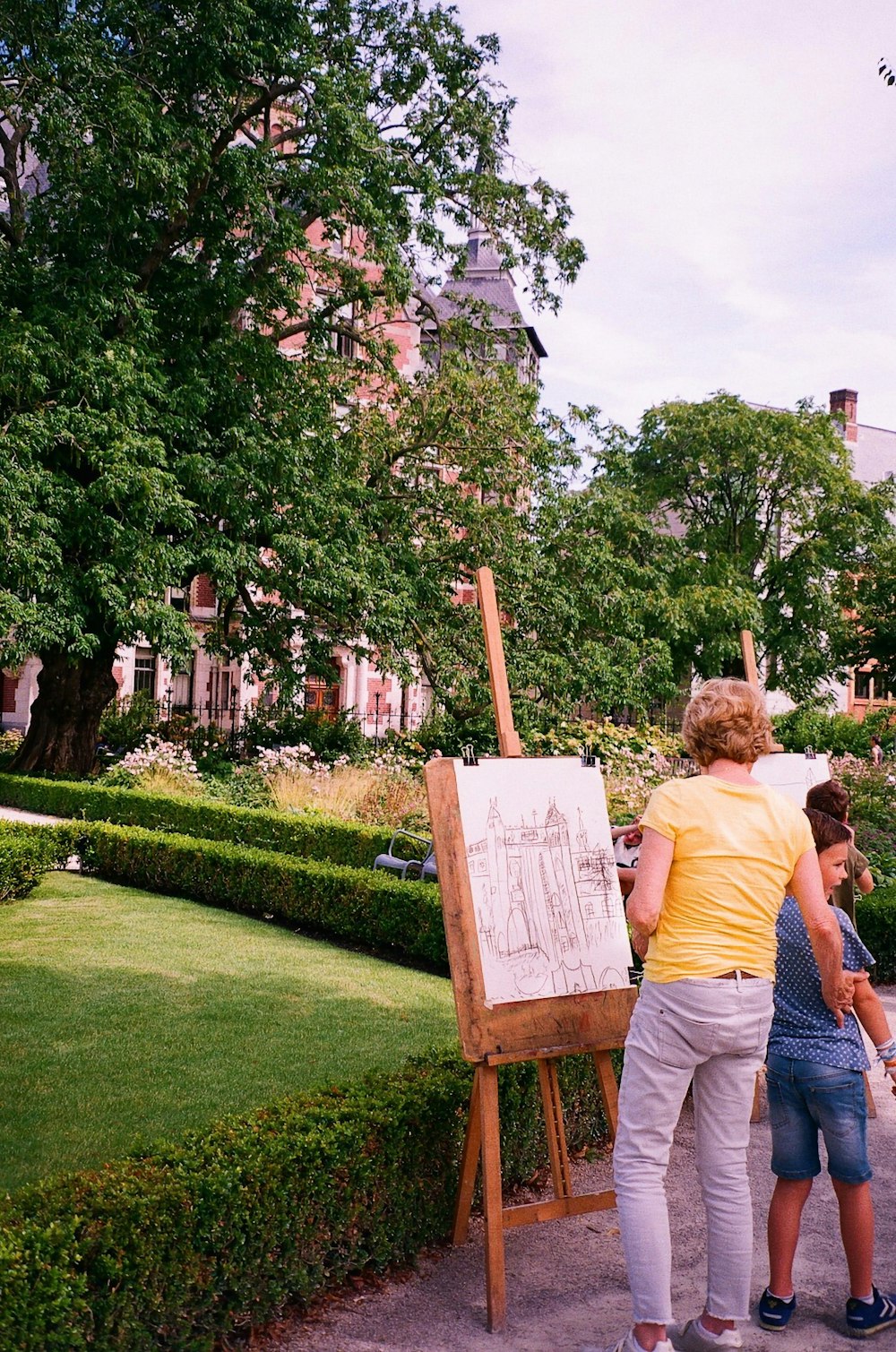 a couple of people standing in front of a easel