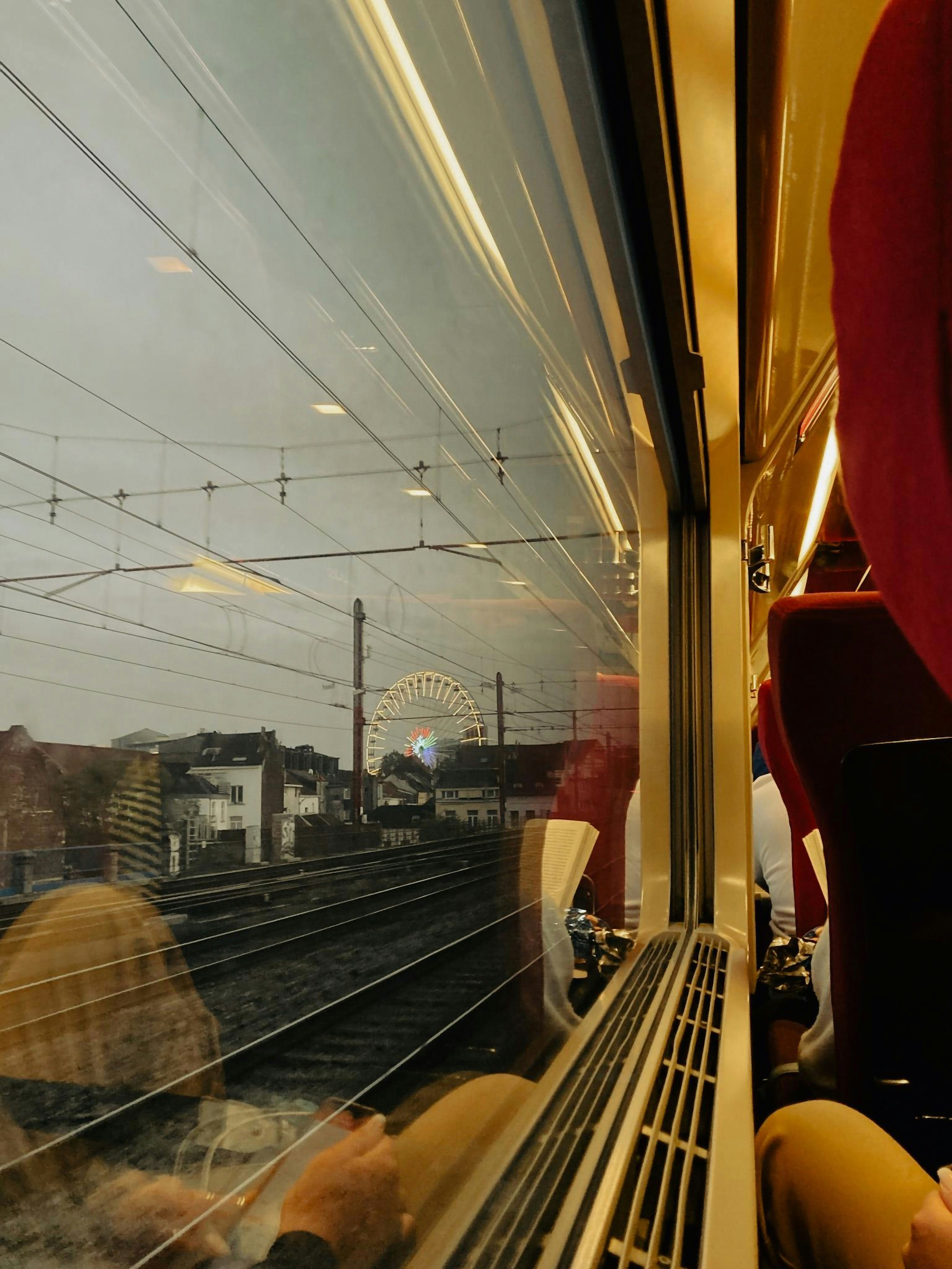 a view of a ferris wheel through a train window