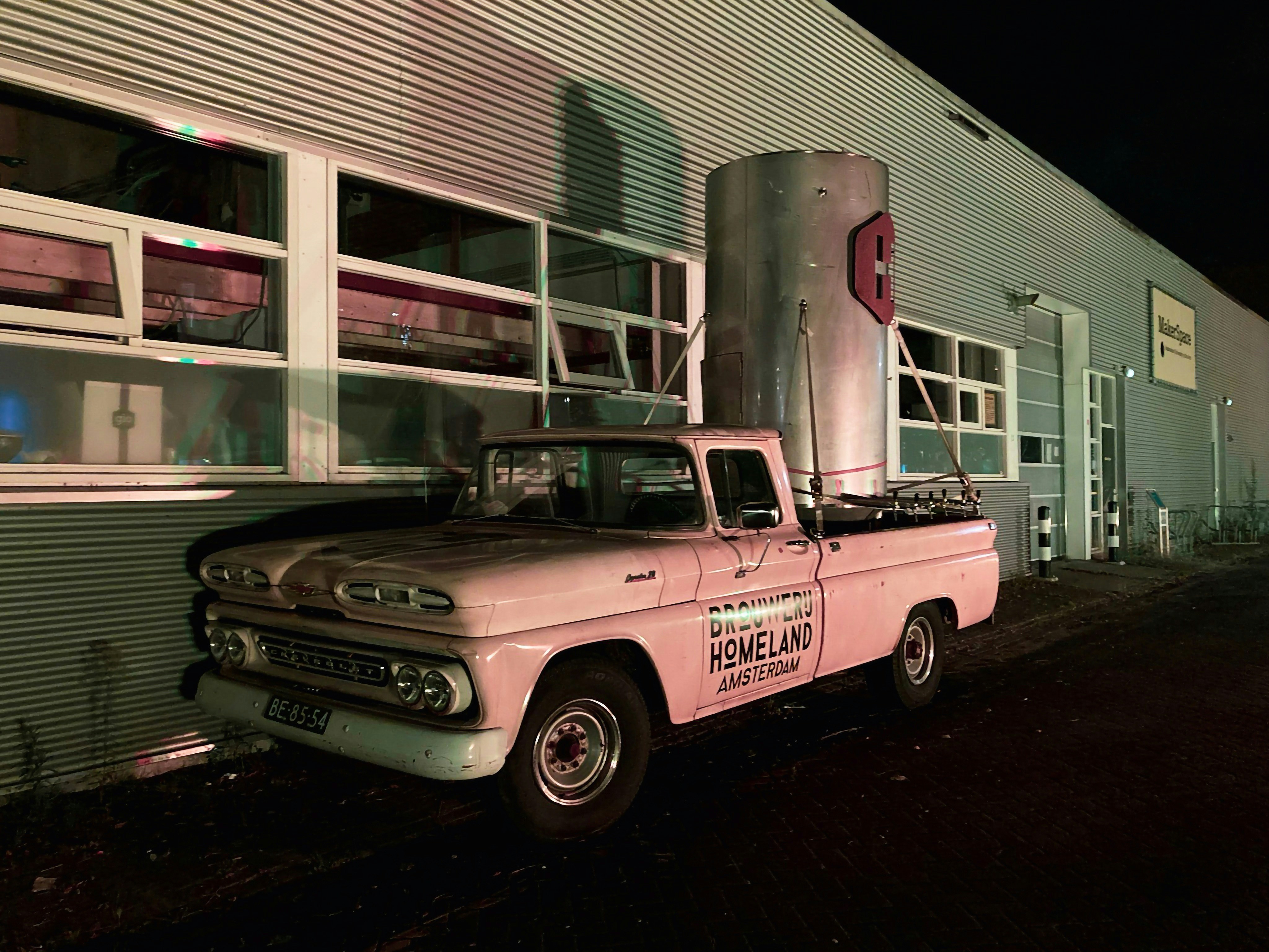 a pink truck parked in front of a building