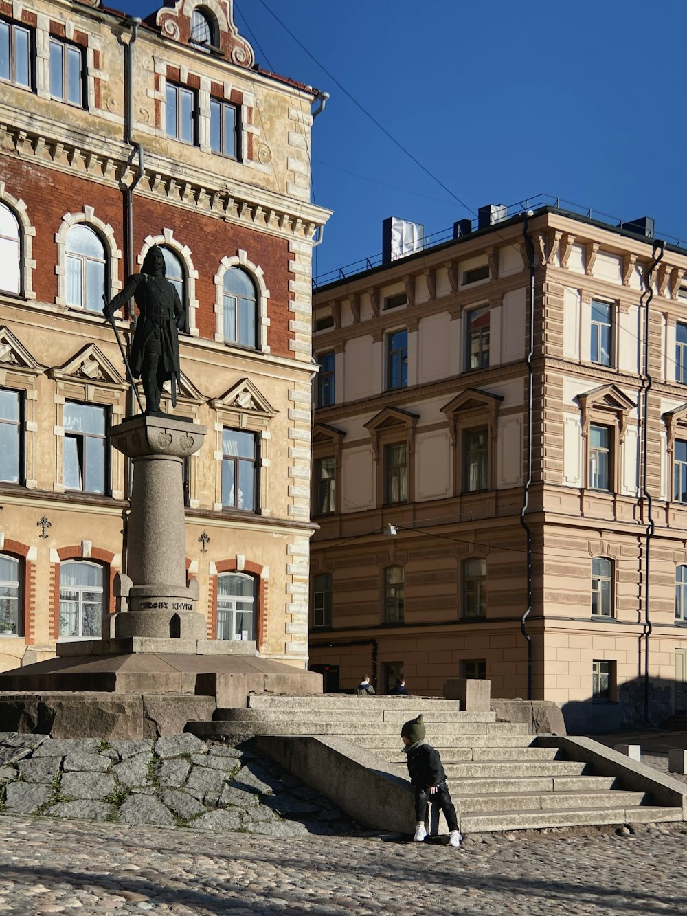 a statue of a man on a pedestal in front of a building