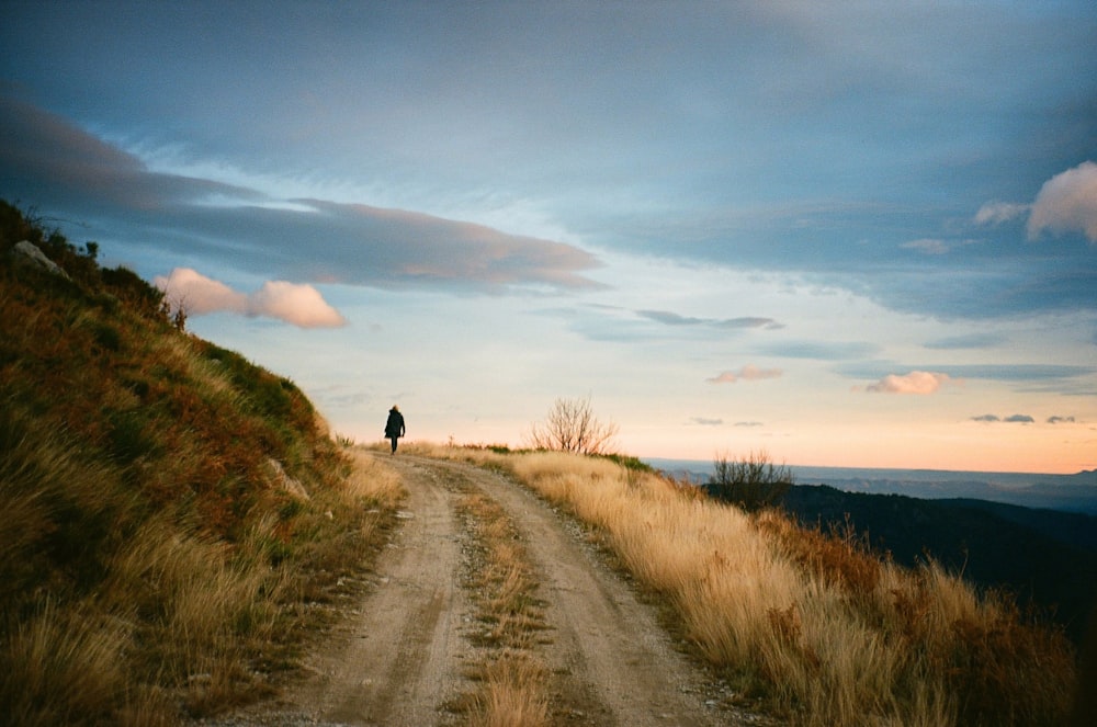 a person standing on top of a dirt road