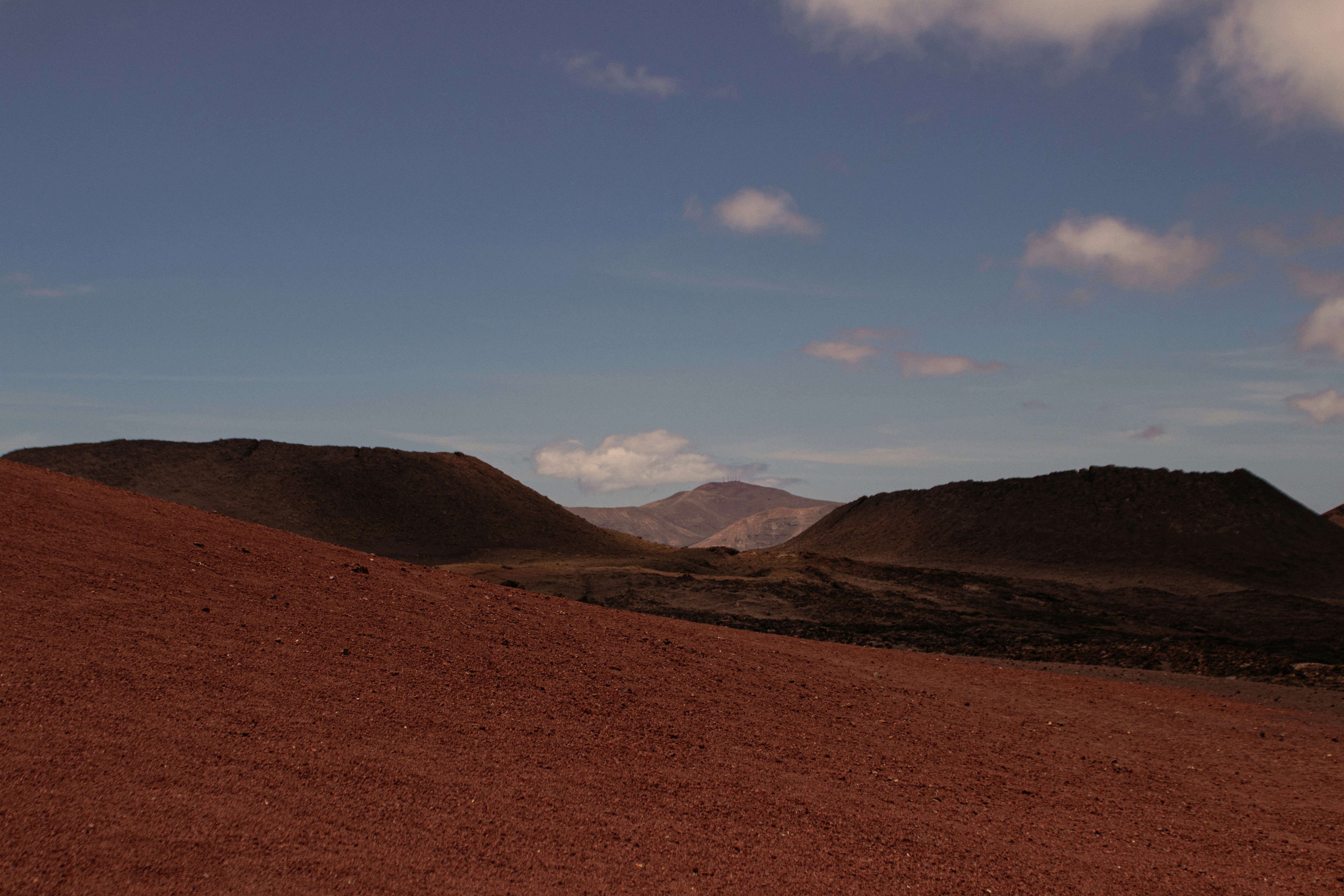 um campo de terra com montanhas no fundo