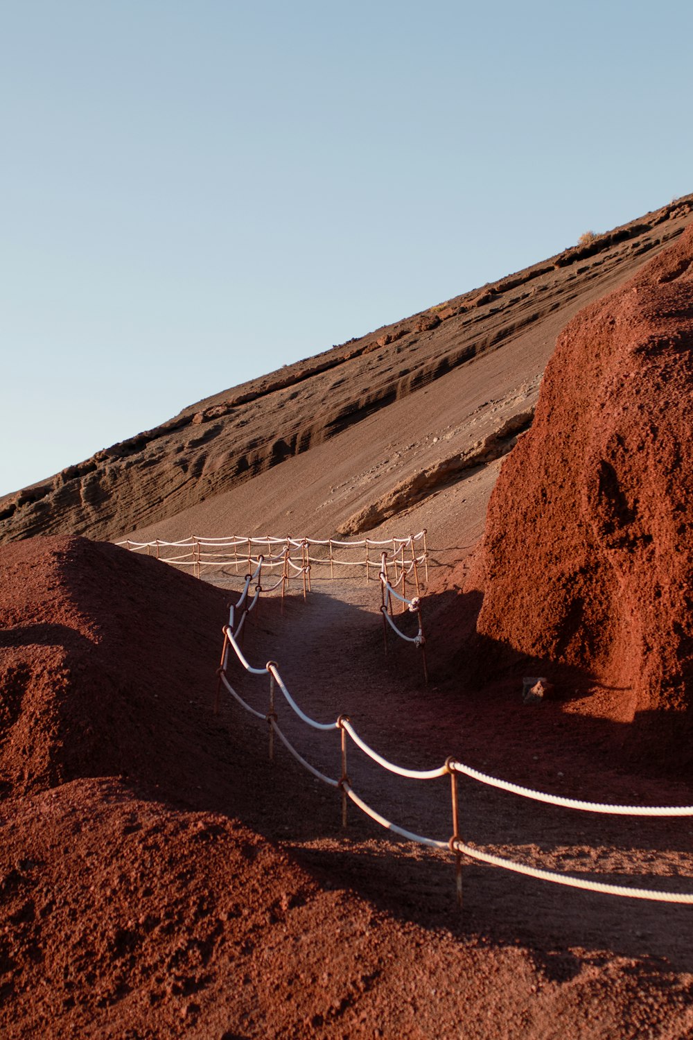 a dirt hill with a wooden walkway going up it