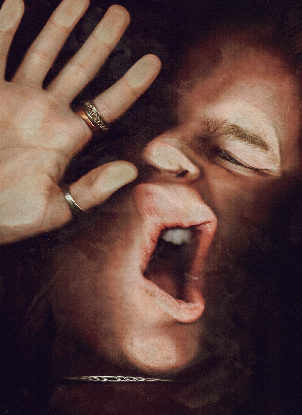 a man with his mouth open with his hands on his face