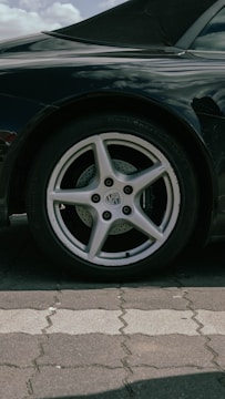 A dynamic car influencer testing a new set of high-performance tires on a sunlit London street.