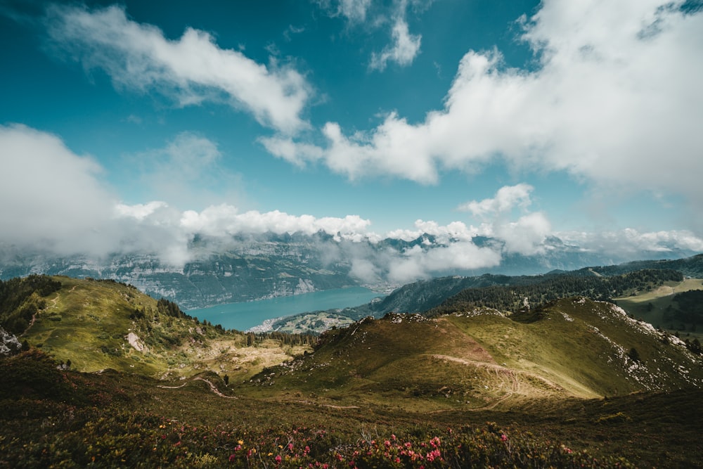 a scenic view of a mountain range with a lake in the distance