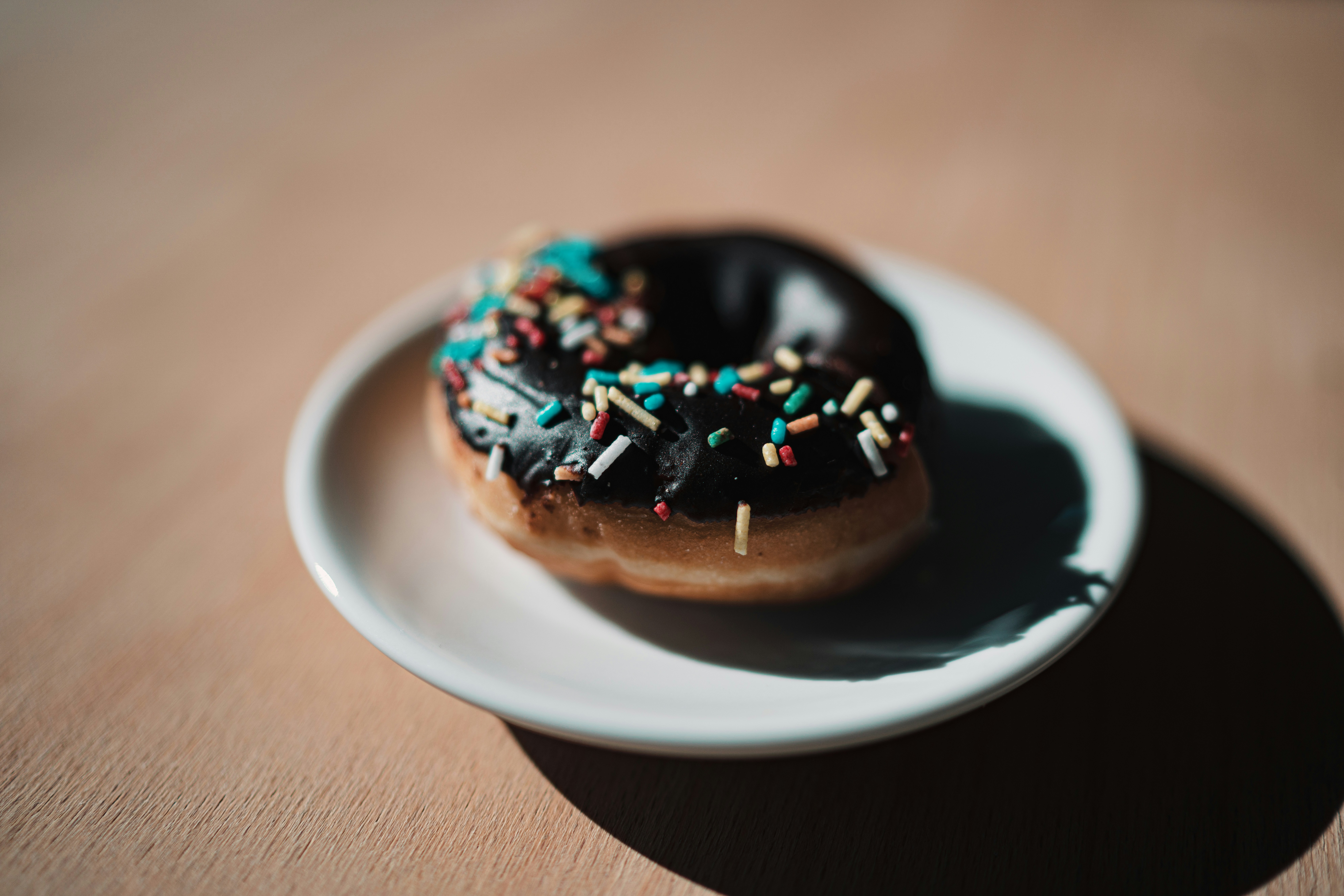 Um donut de chocolate com polvilhos em um prato foto – Imagem grátis na  Unsplash, image size:3000x2001