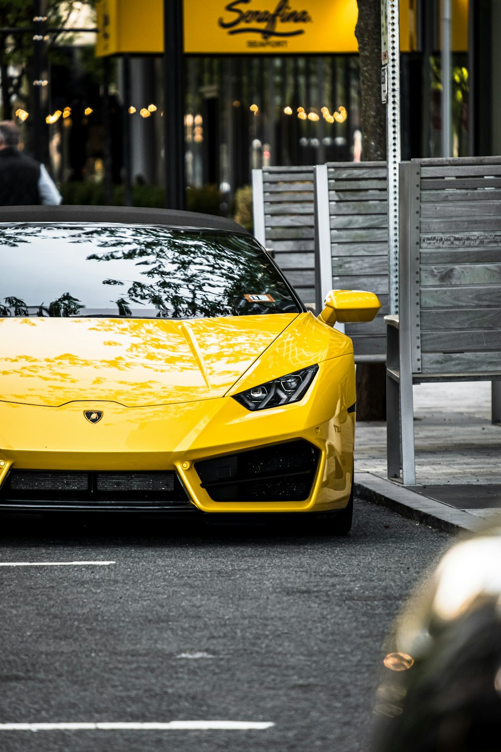a yellow sports car parked in front of a restaurant