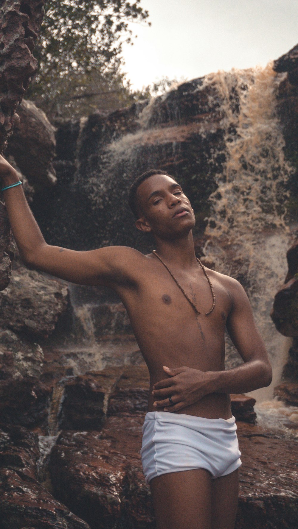 a man standing in front of a waterfall holding a frisbee