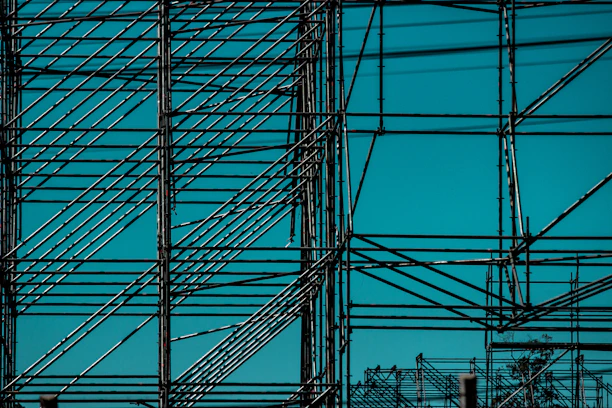 Close-up of sturdy metal scaffolding with a clear blue sky background.