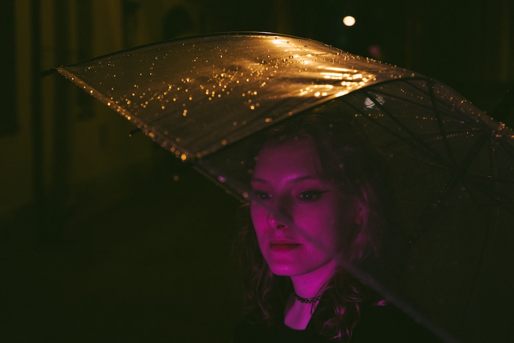 a woman holding an umbrella in the dark