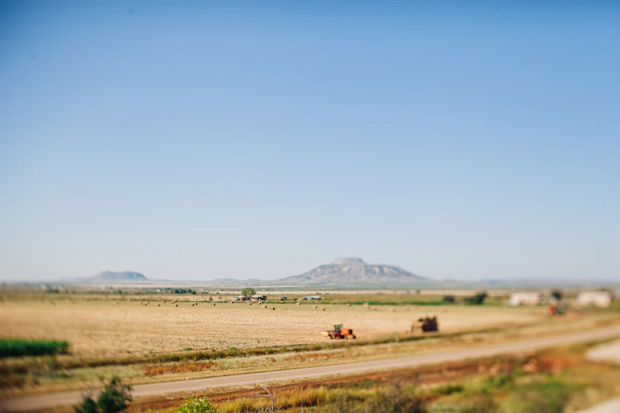 A farm field with mountains in the background