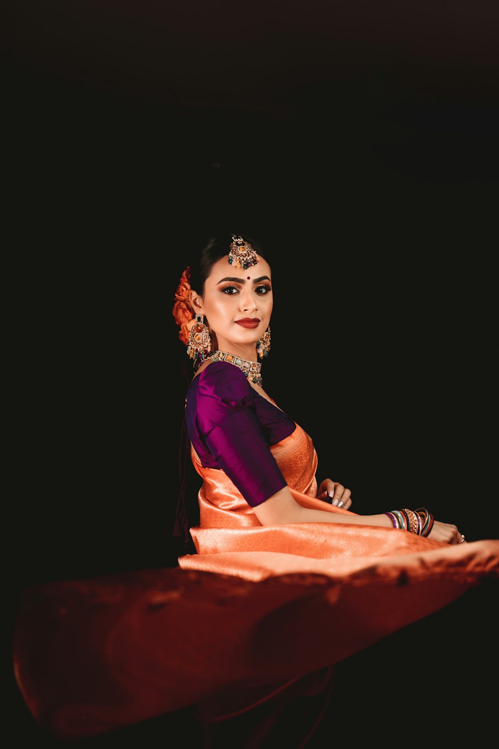 a woman in a purple and orange sari