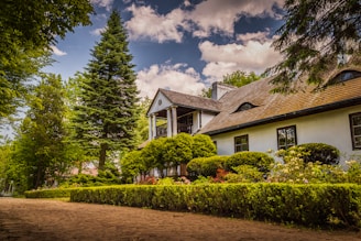 a white house surrounded by trees and bushes