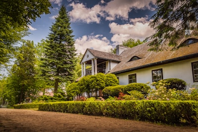 a white house surrounded by trees and bushes