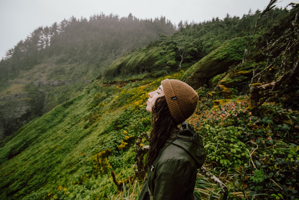 a woman standing on a lush green hillside