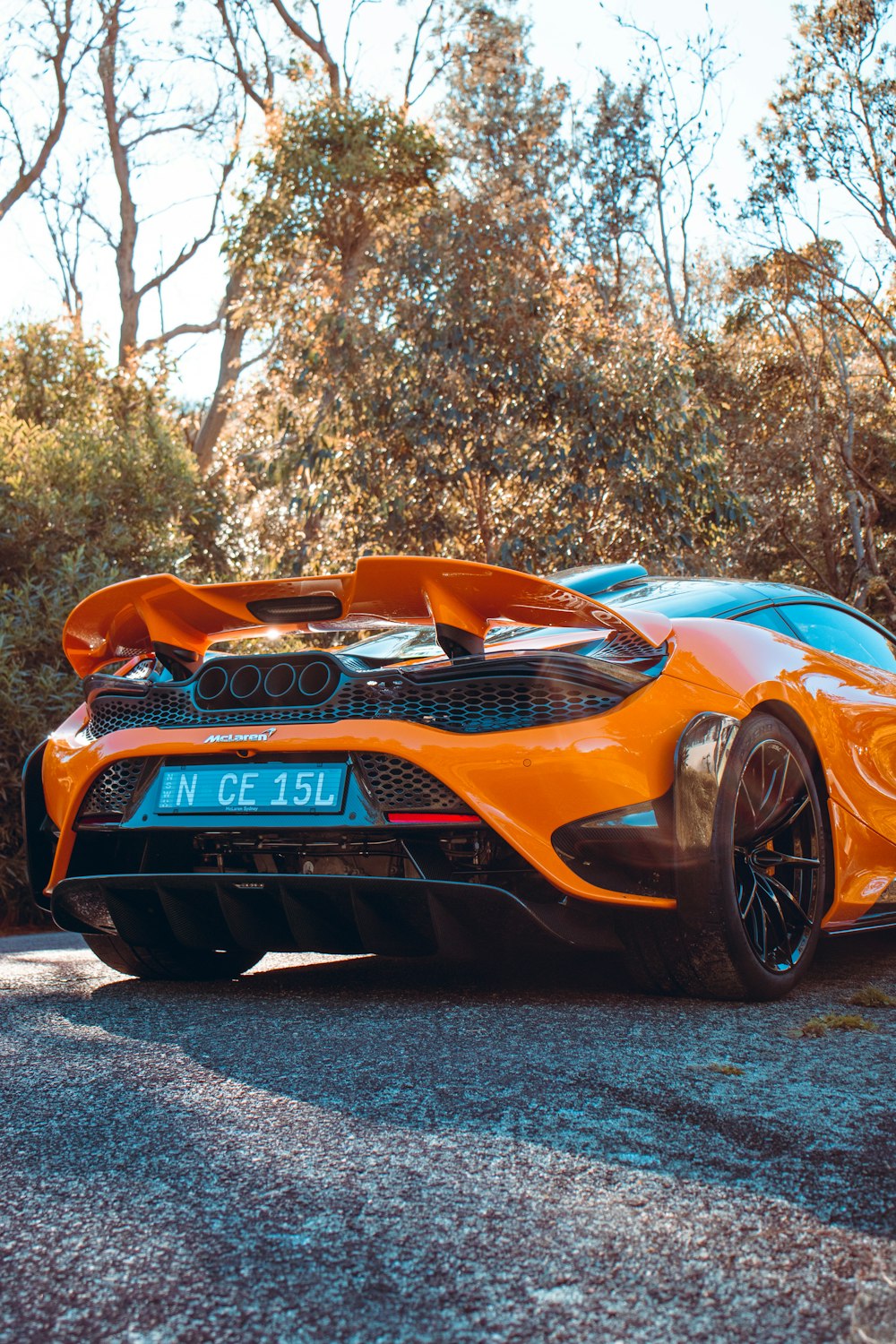 an orange sports car parked on the side of the road