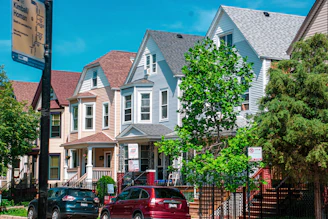 a row of houses with cars parked in front of them
