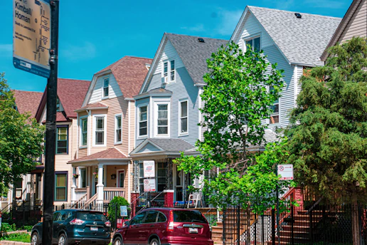 a row of houses with cars parked in front of them
