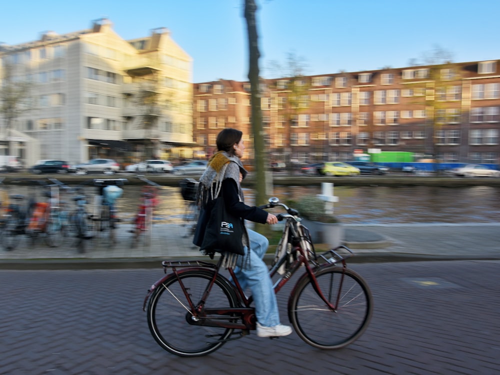 a man riding a bike down a street next to a river