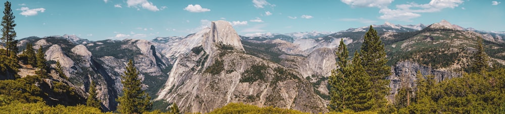 a view of a mountain range with trees and mountains in the background