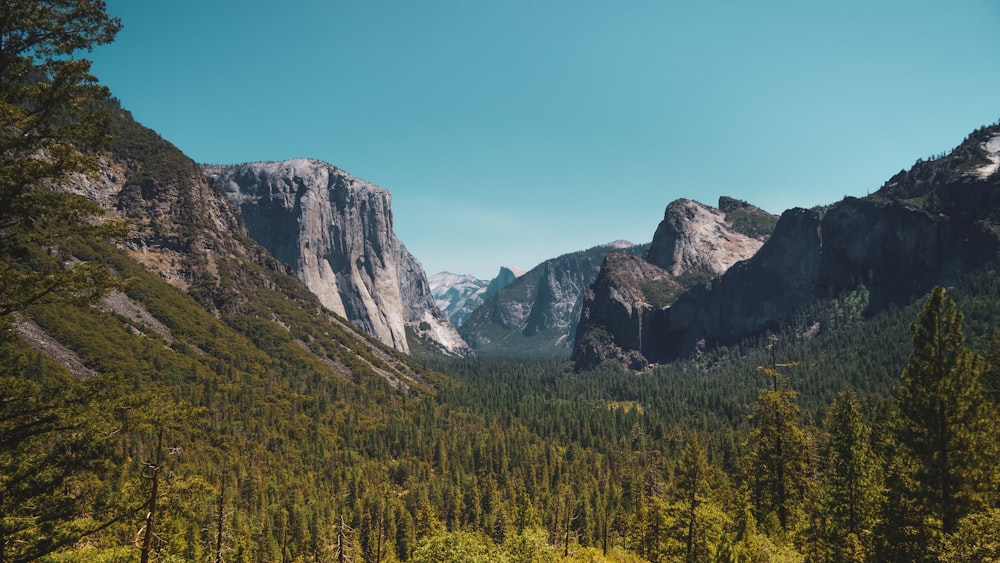 a view of a mountain range with trees and mountains in the background