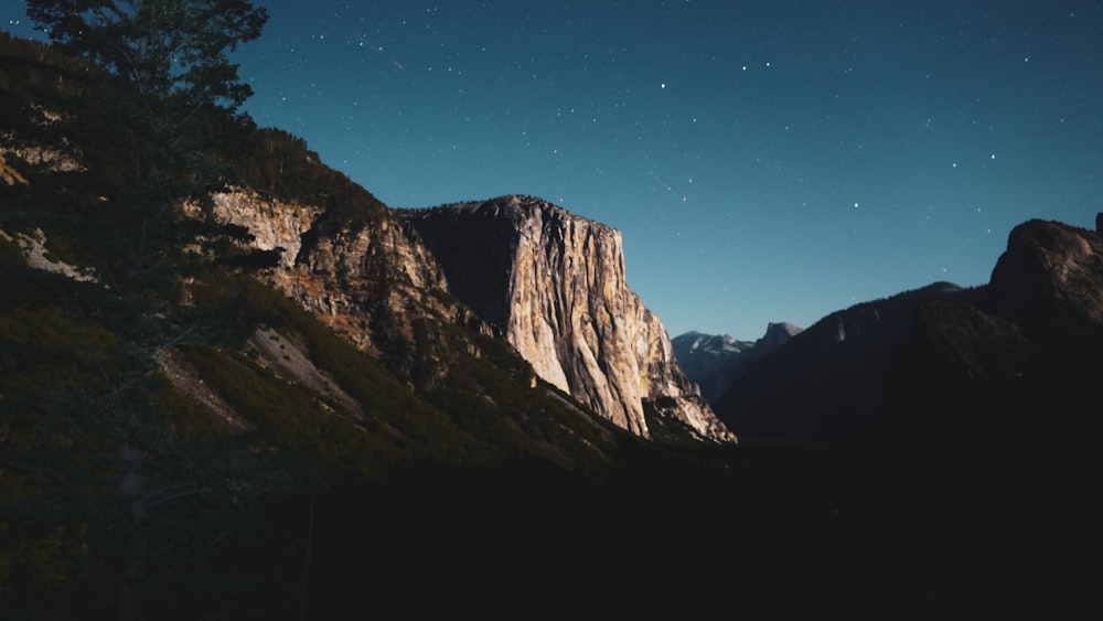 the night sky over a mountain range with stars in the sky