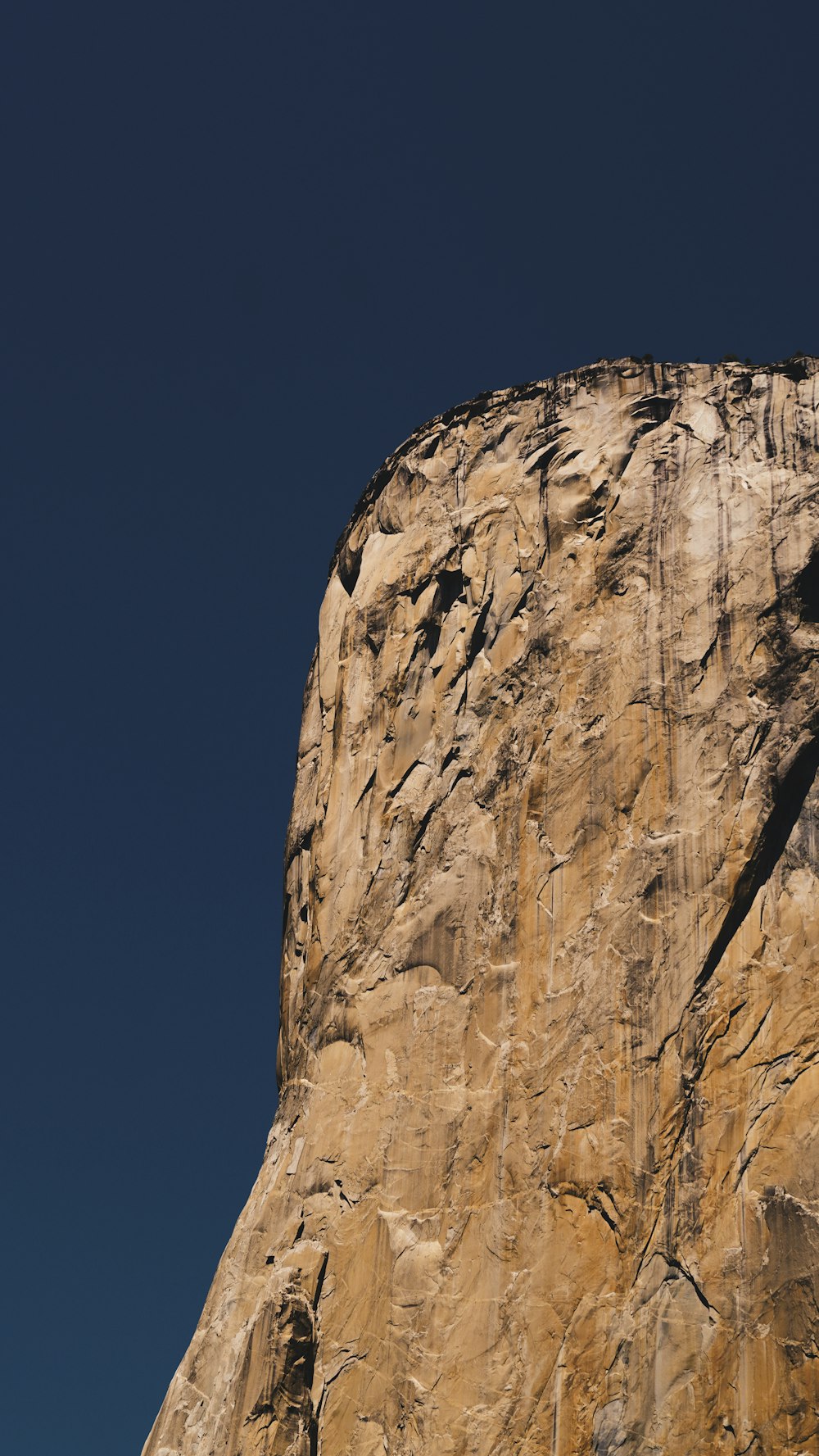 a rock face with a clear blue sky in the background