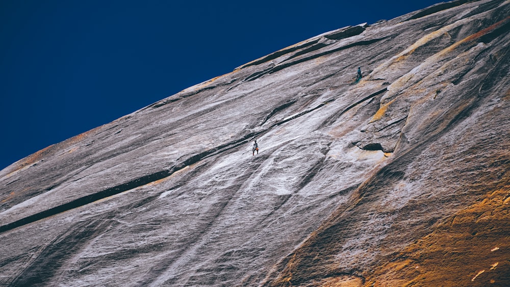 a man climbing up the side of a mountain