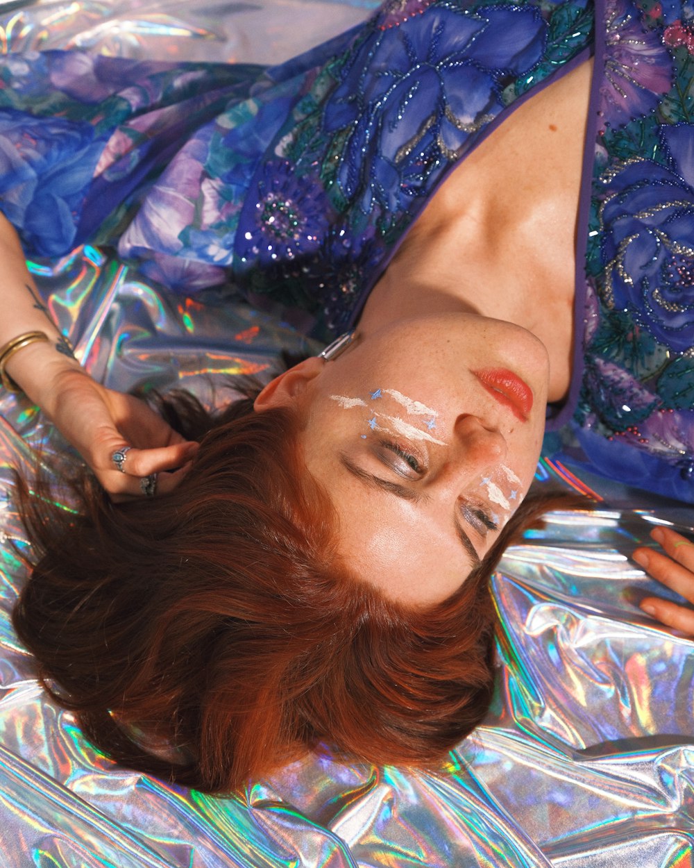 a woman laying on top of a shiny surface