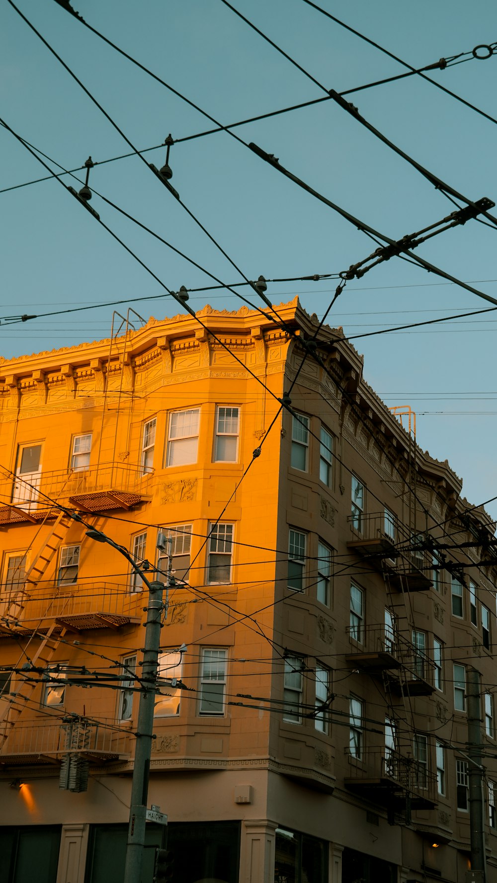 un bâtiment jaune avec beaucoup de fenêtres à côté d’une rue