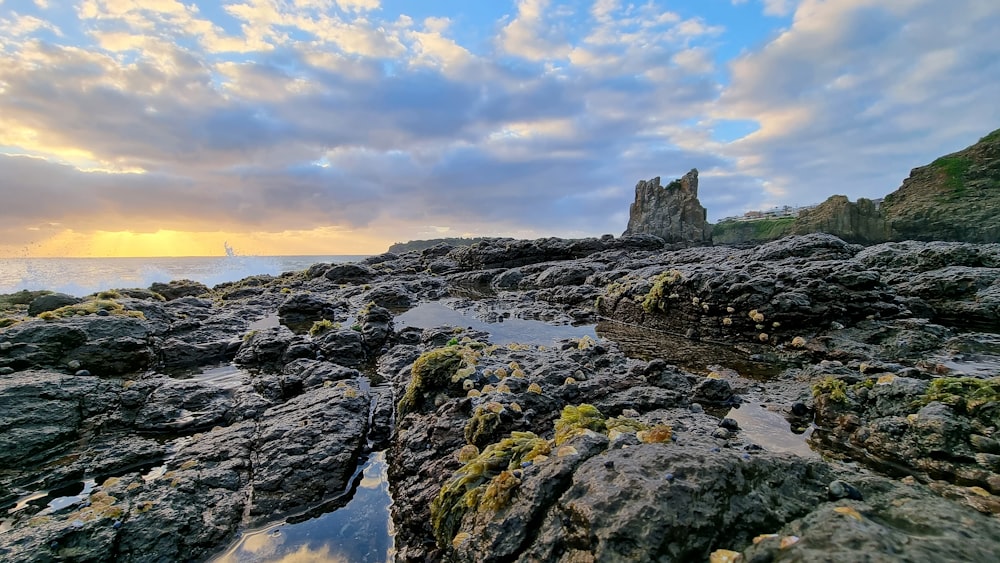 a rocky beach with a rock formation in the foreground