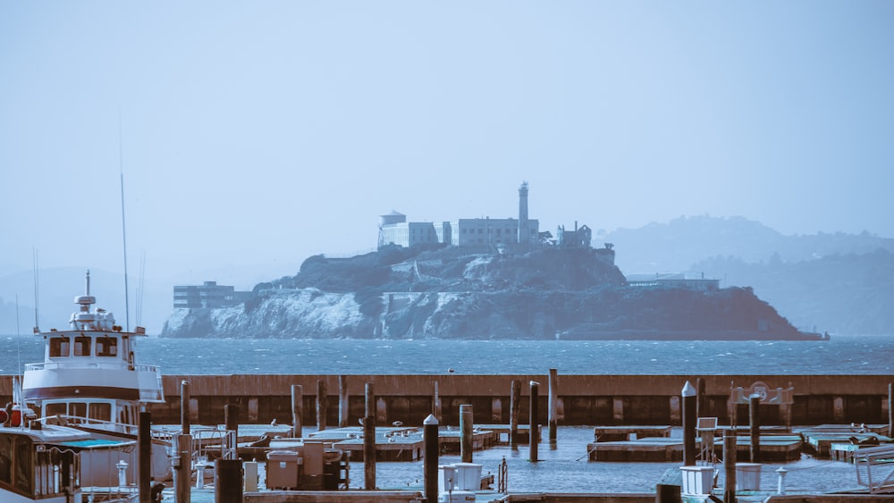 a boat docked at a pier with a castle in the background