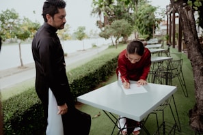 a man standing next to a woman at a table