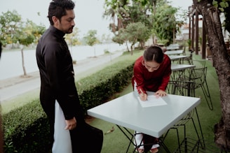 a man standing next to a woman at a table